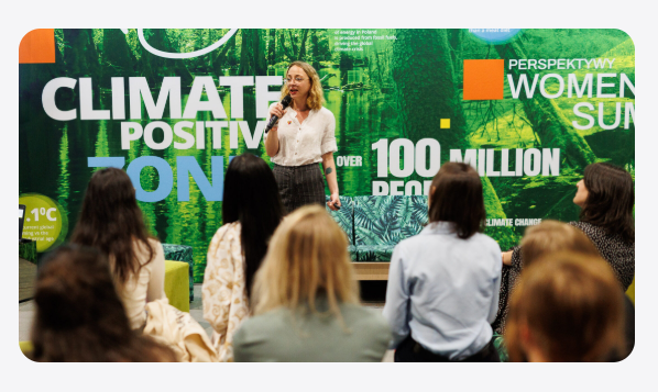 Magda Kufrej speaking in front of a Climate Positive On backdrop